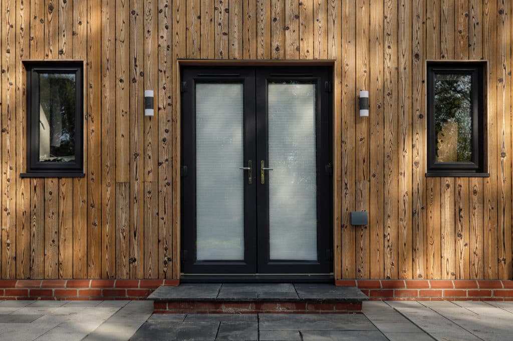 Porte d'entrée d'une maison équipée d'une façade en bois clair