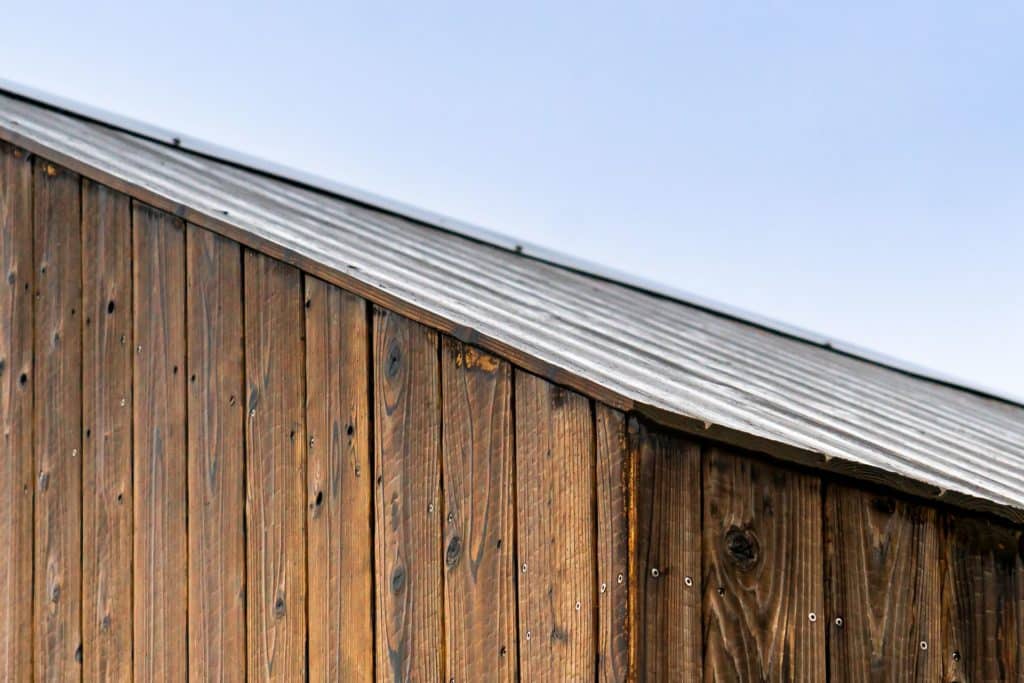 façade en bois brun clair avec toit pointu et ciel bleu