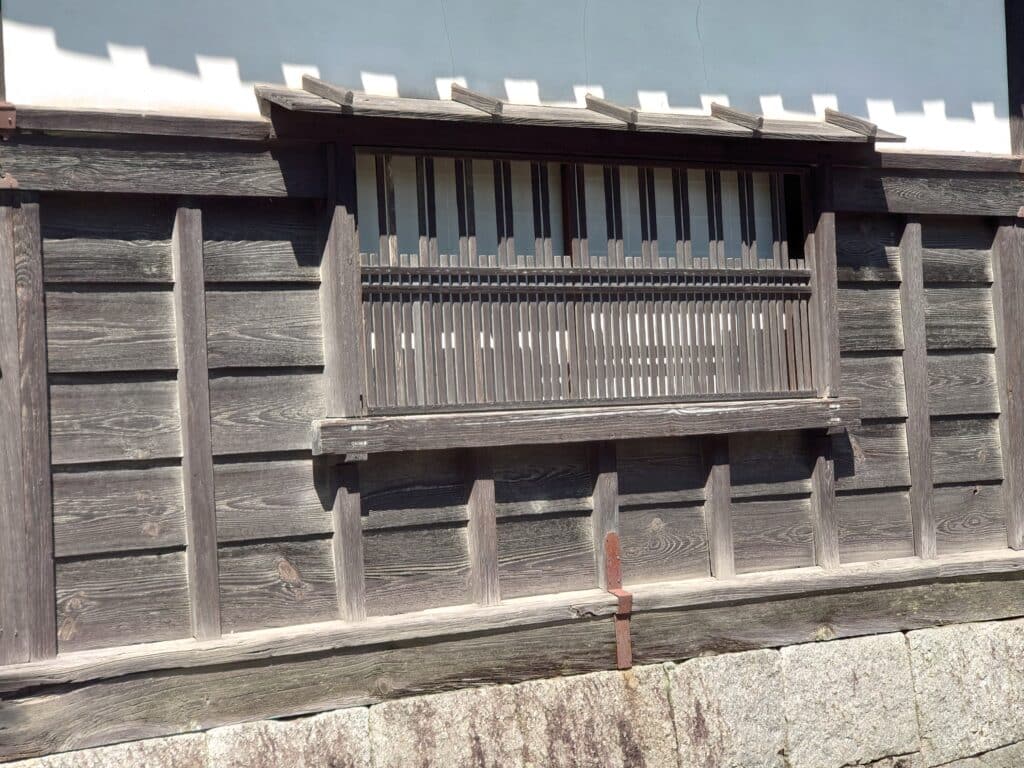 Fenêtre intégrée dans le bardage en bois d'une ancienne maison japonaise